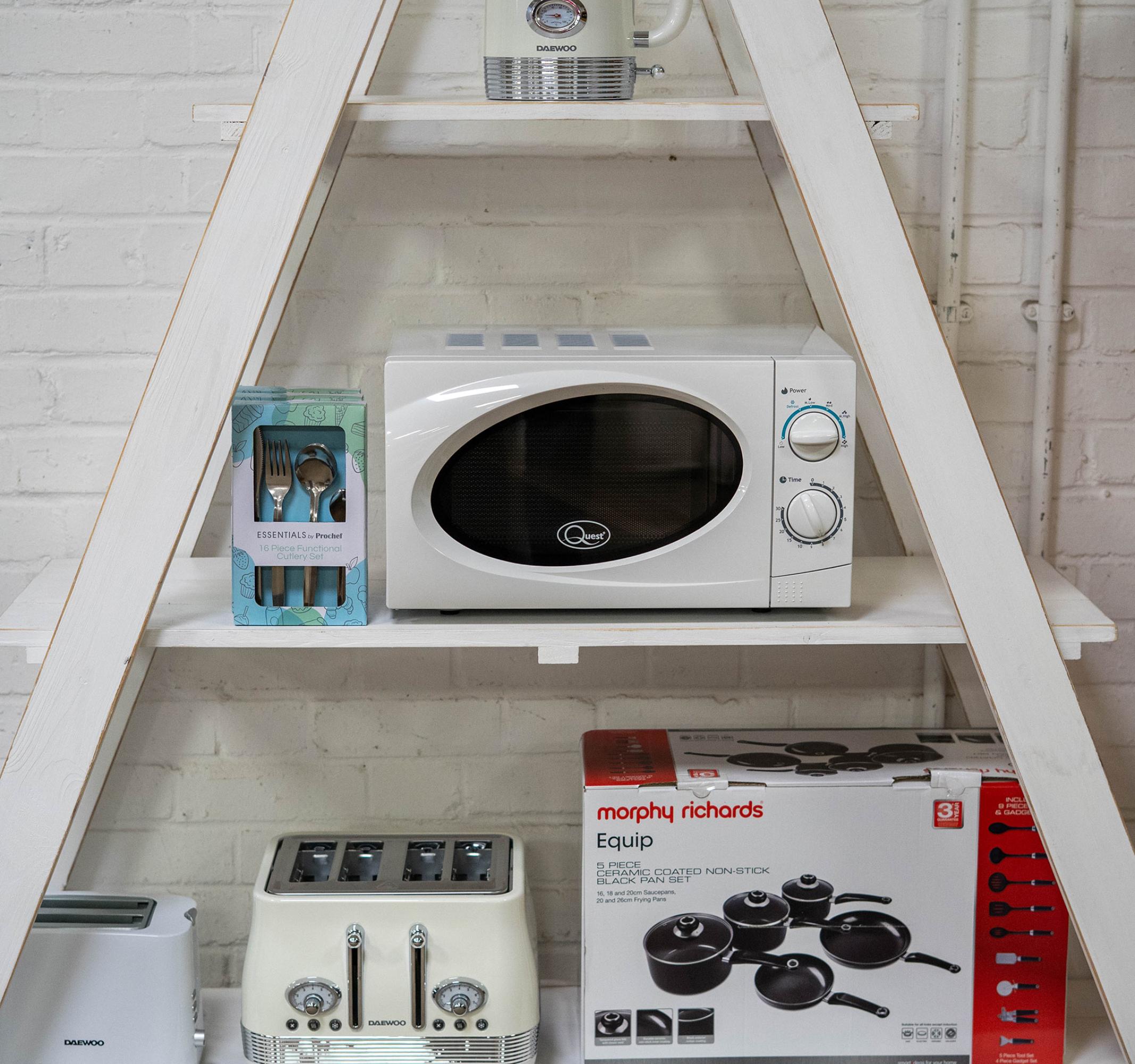 A selection of kitchen electrical products on a white shelving unit.
