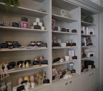 Shop shelves displaying gift items, candles, and decorative crafts.