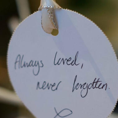 White tag reads "Always loved, never forgotten," hanging from a string.