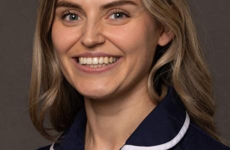 Smiling blonde woman in a dark blue St Michael's Hospice uniform.