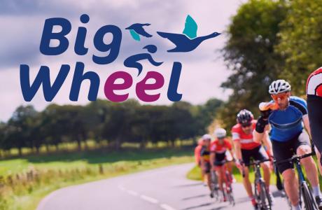 Graphic: Big Wheel logo over road cyclists racing through a green landscape.