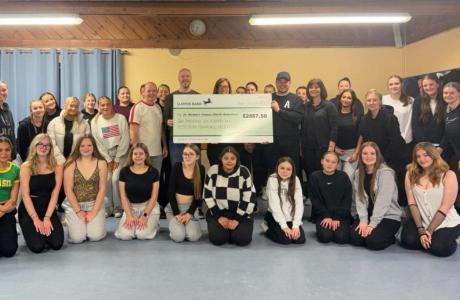 Members of the Happy Feet Dance Academy presenting a cheque