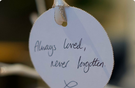 White tag reads "Always loved, never forgotten," hanging from a string.