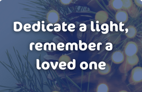 Blurred background of pine needles, pinecones, and warm string lights.