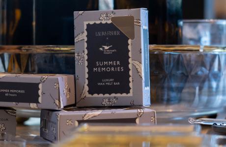 Dark blue box labeled "SUMMER MEMORIES" with other products on a retail display.