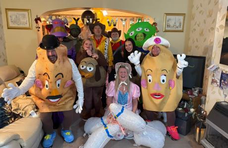 Photograph of a group of adults in fun costumes, including Mr. &amp; Mrs. Potato Head, and Woody.