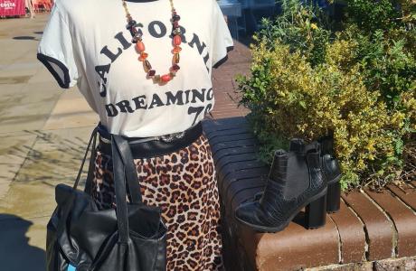 Photograph of a manikin wearing a leopard print skirt and white t-shirt