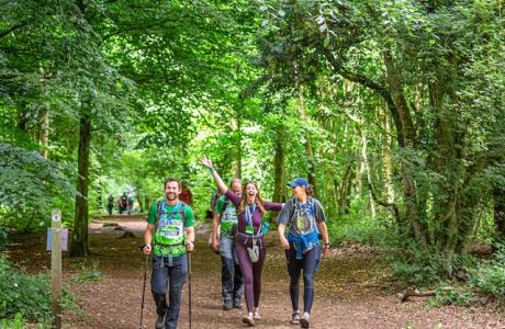 Groups of people smiling walking through the woods during the Cotswold Way Ultra Challenge