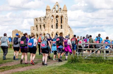 Image of a crowd of people doing the walk by Whitby Abbey