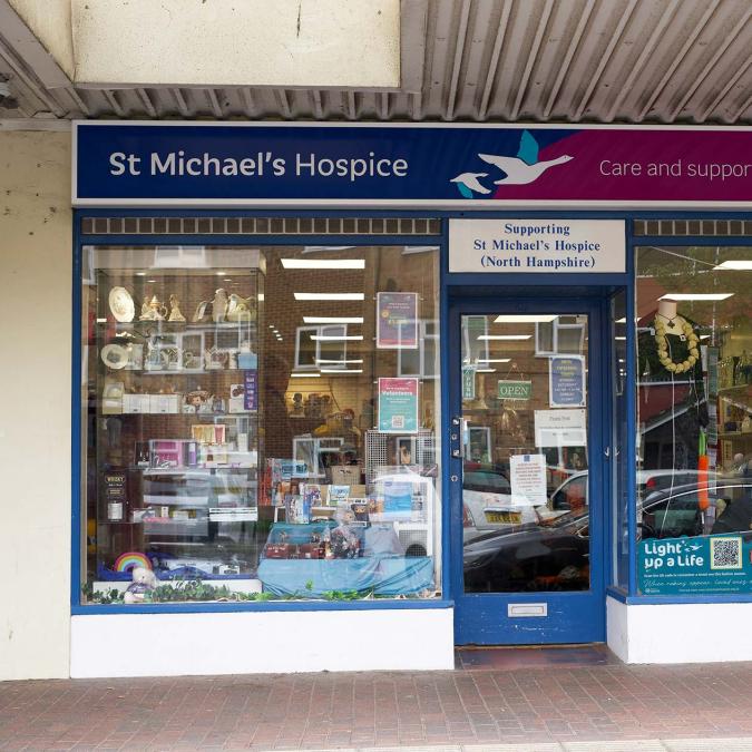 St Michael's Hospice charity shop storefront, one window with Halloween decorations.