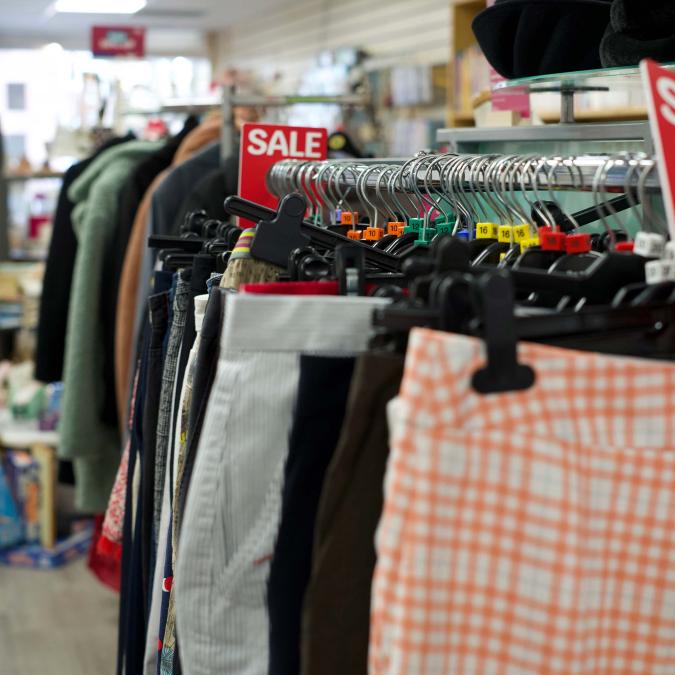 Close-up of a clothing rack displaying pants for sale in a retail store.