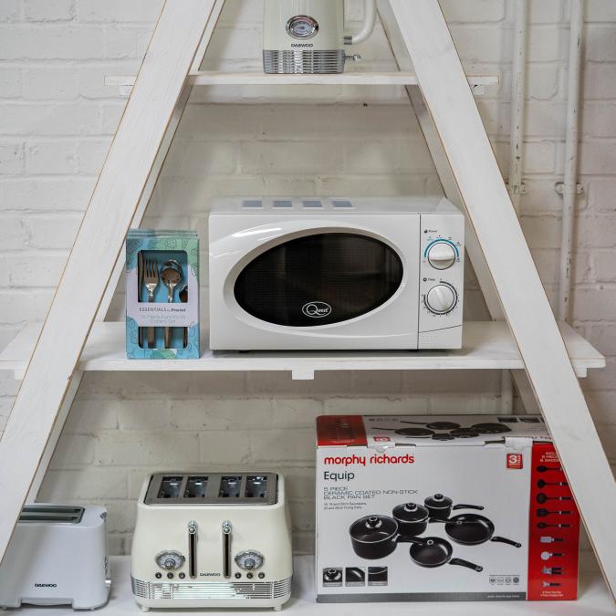 A selection of kitchen electrical products on a white shelving unit.