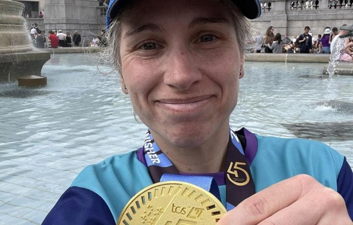 Lisa holding her medal smiling proudly at the camera after the London Marathon