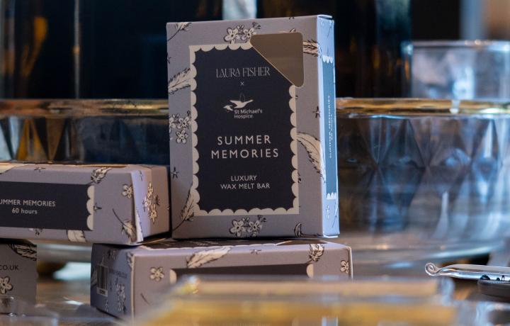 Dark blue box labeled "SUMMER MEMORIES" with other products on a retail display.