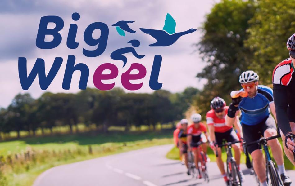 Graphic: Big Wheel logo over road cyclists racing through a green landscape.