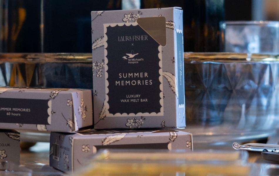 Dark blue box labeled "SUMMER MEMORIES" with other products on a retail display.
