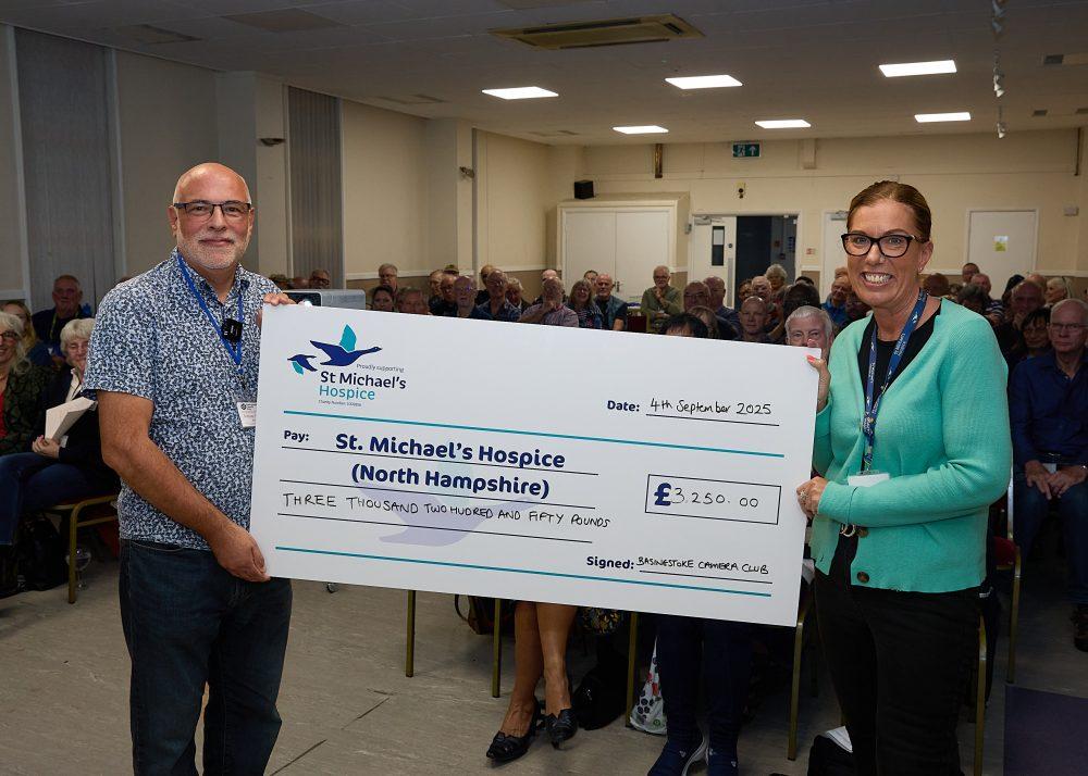 Man and woman holding a large check for St. Michael's Hospice, £1,350.00.