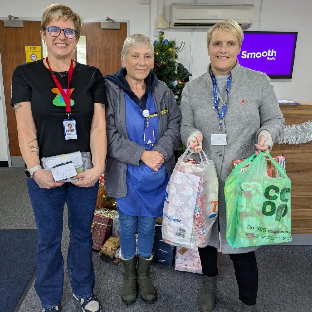 3 people carrying bags of presents