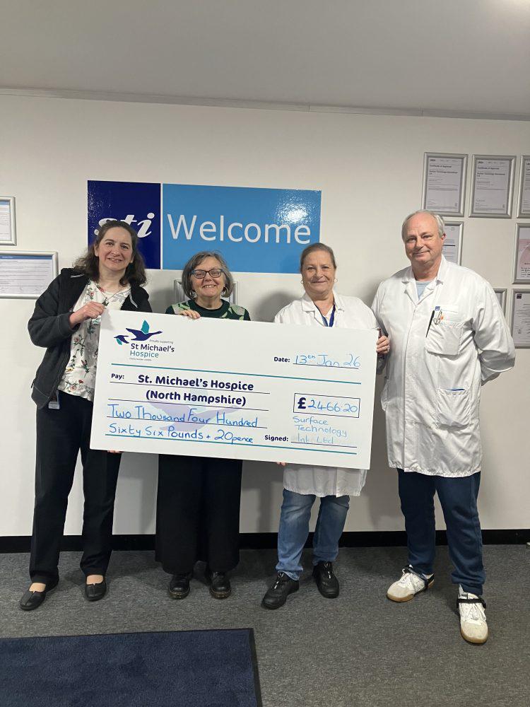 Four people hold a large novelty check for St. Michael's Hospice.