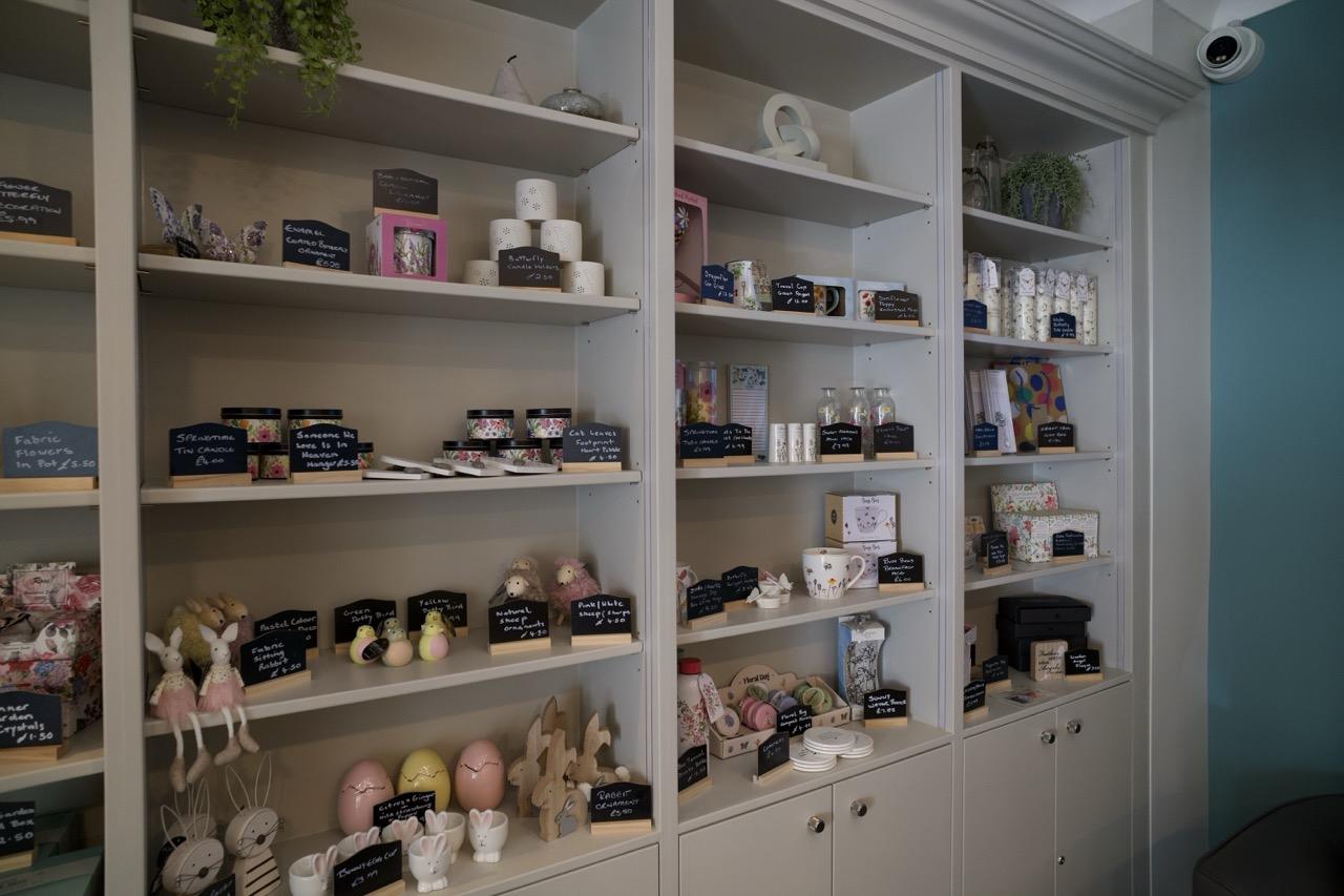 Shop shelves displaying gift items, candles, and decorative crafts.