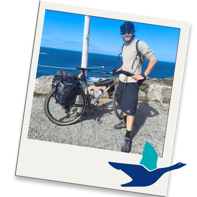 Photograph of Max posing happily with his bike during his challenge