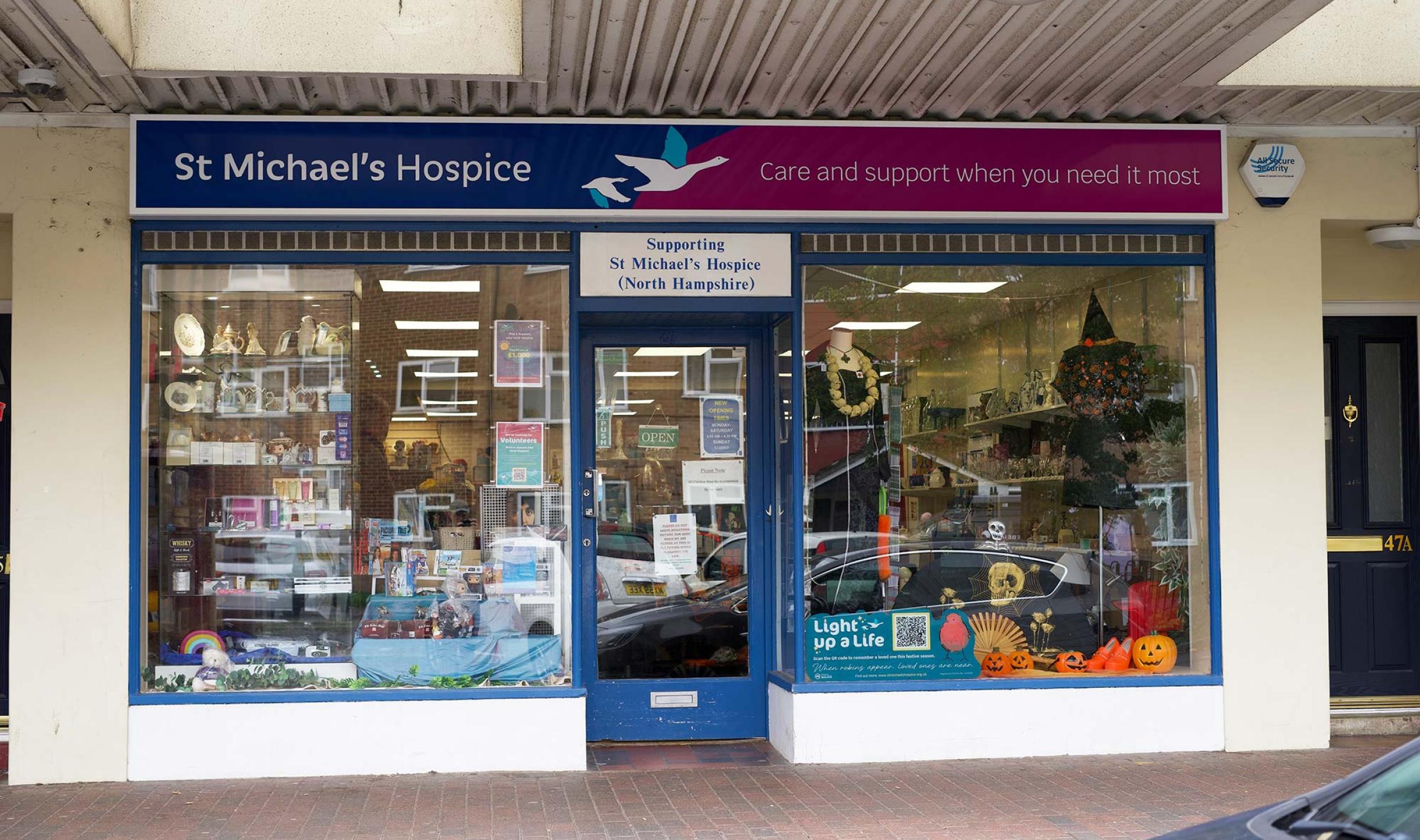 St Michael's Hospice charity shop storefront with Halloween-themed window display.