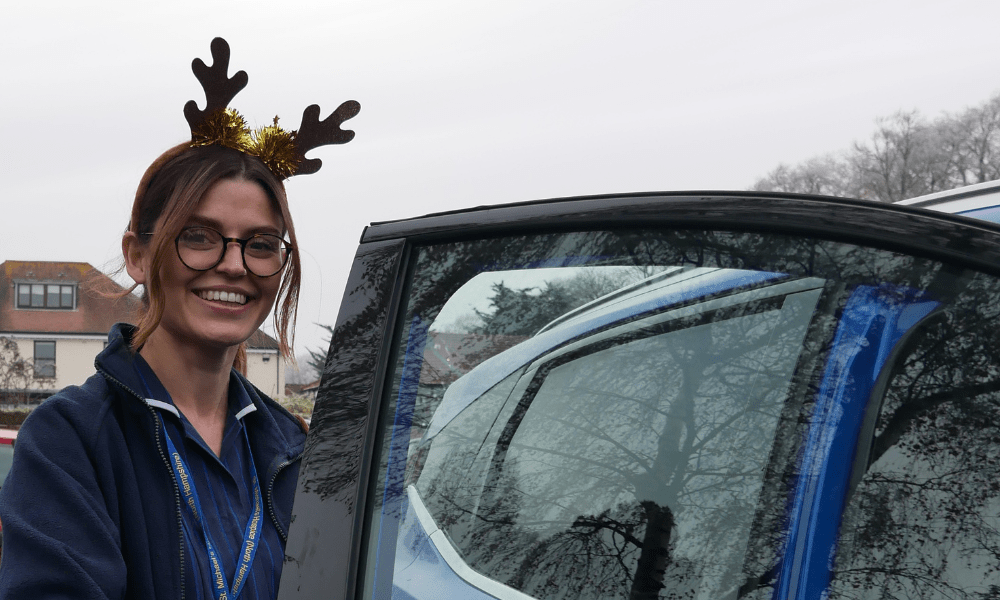 Hospice at Home nurse getting into a car wearing antlers