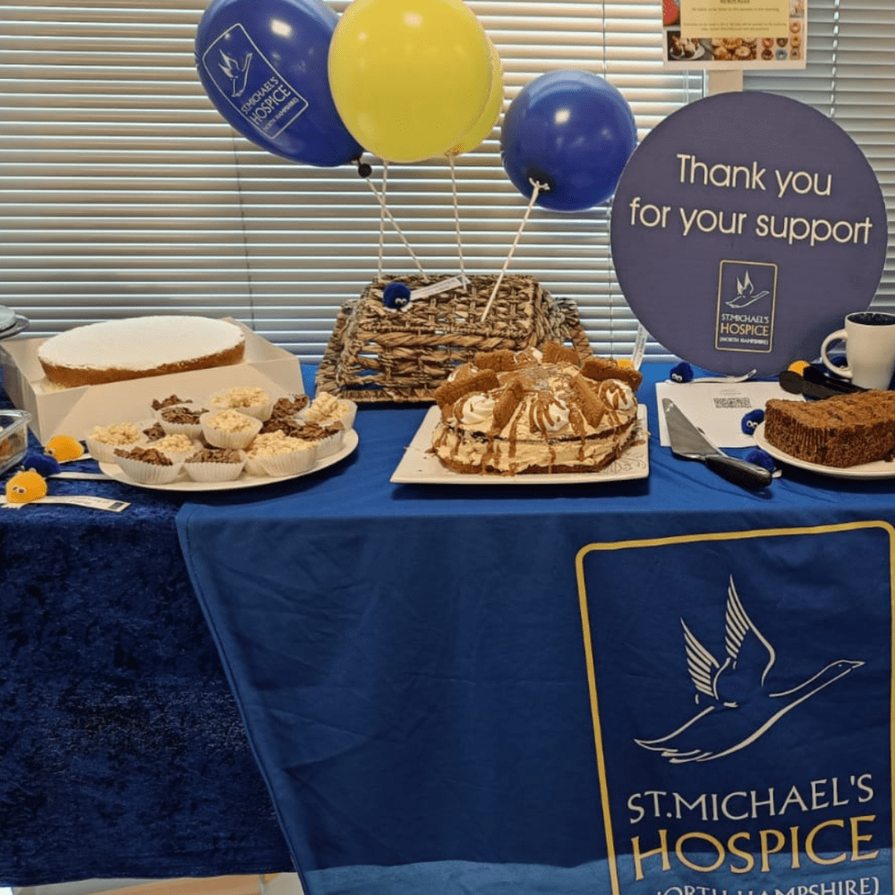 A table full of cakes with a sign saying Thank you for your support