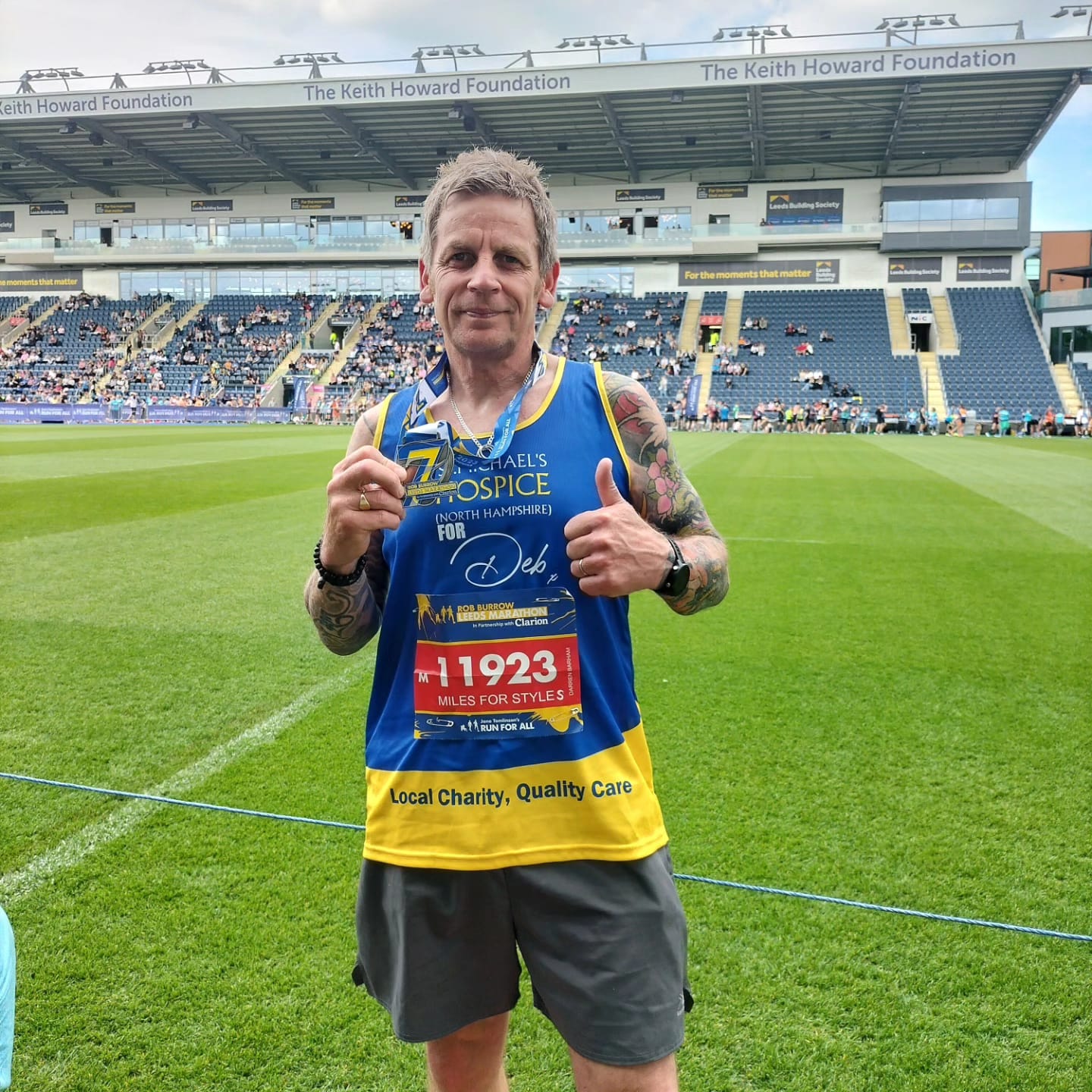 Darren holding his medal after taking part in the Leeds Marathon for us