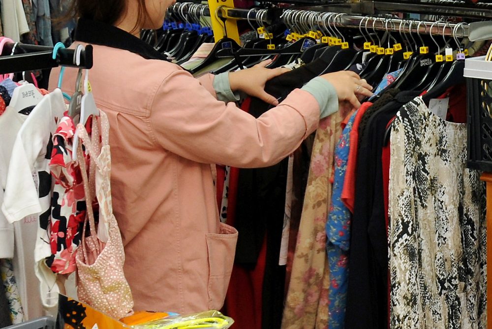 Image of a lady looking through a rail of clothing
